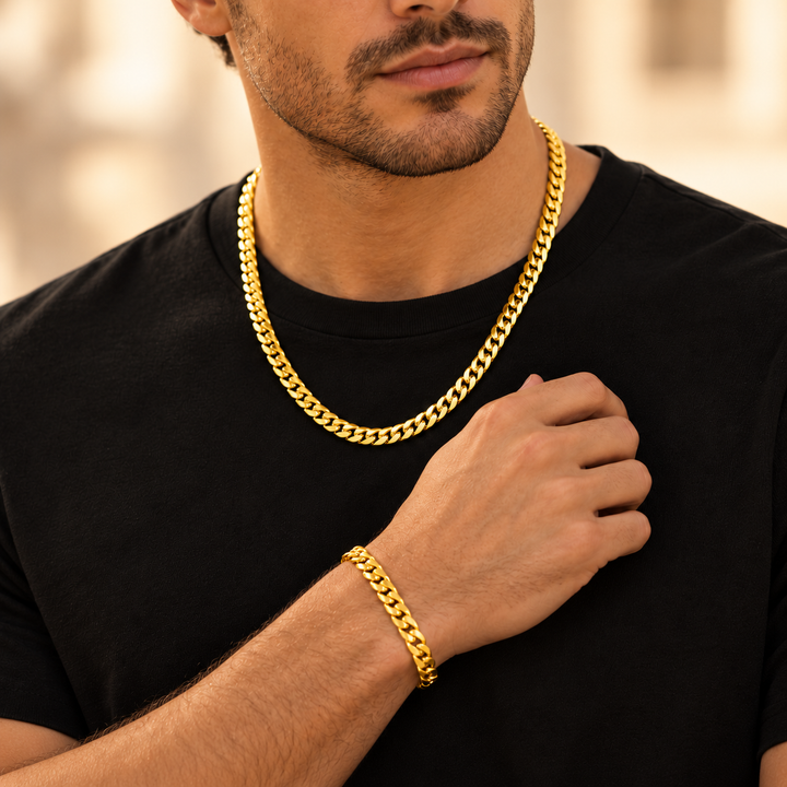 AI-generated styling illustration of a model wearing a Cuban-style chain and bracelet; exact product proportions are not verified. Ilustración de estilo generada con IA; las proporciones exactas del producto no están verificadas.