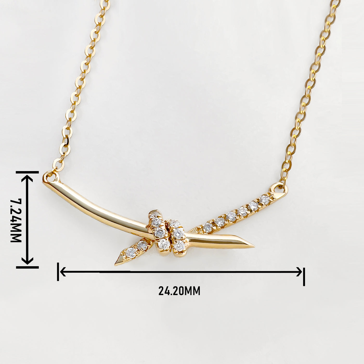 14K gold diamond knot necklace with curved bar pendant and pave diamonds on delicate chain
