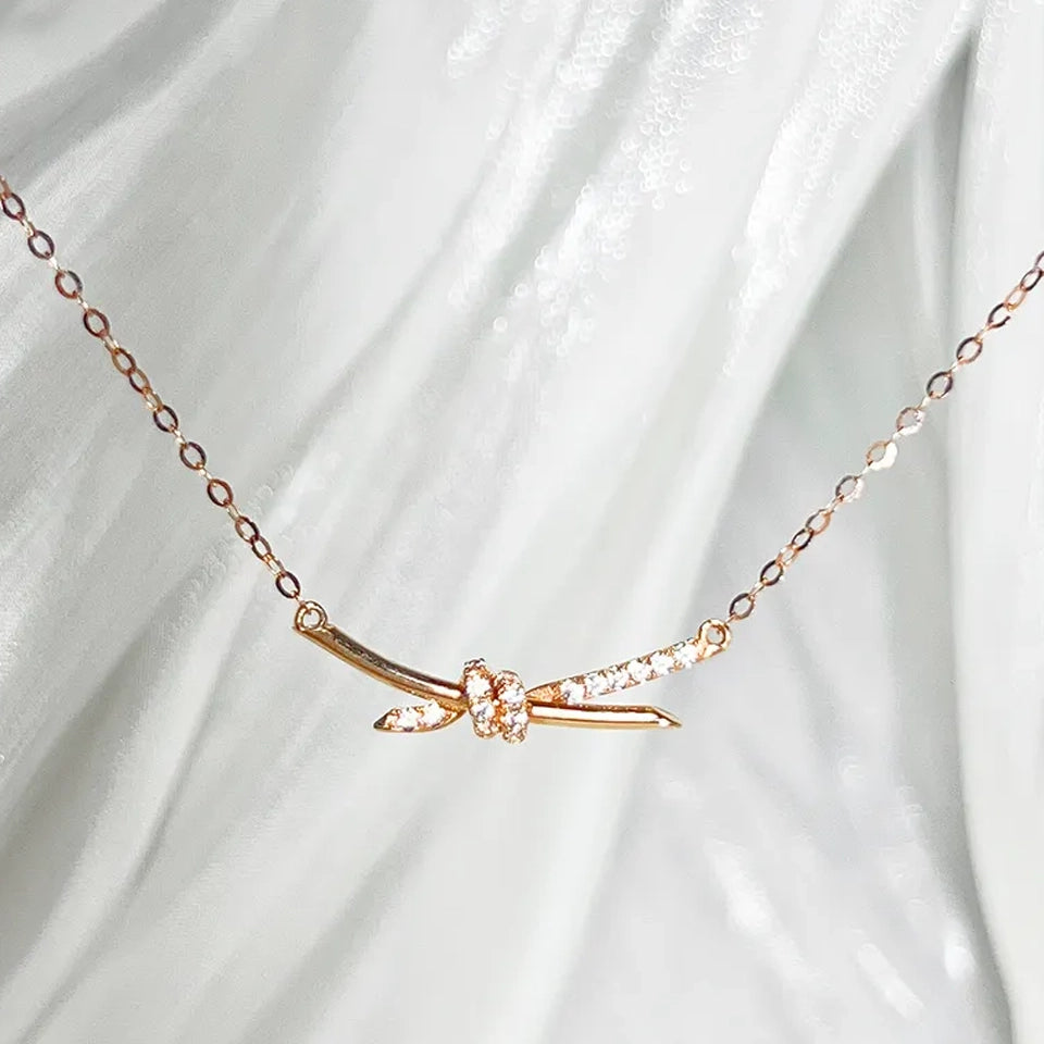 14K gold diamond knot necklace delicate knotted bar pendant with small diamonds on fine chain