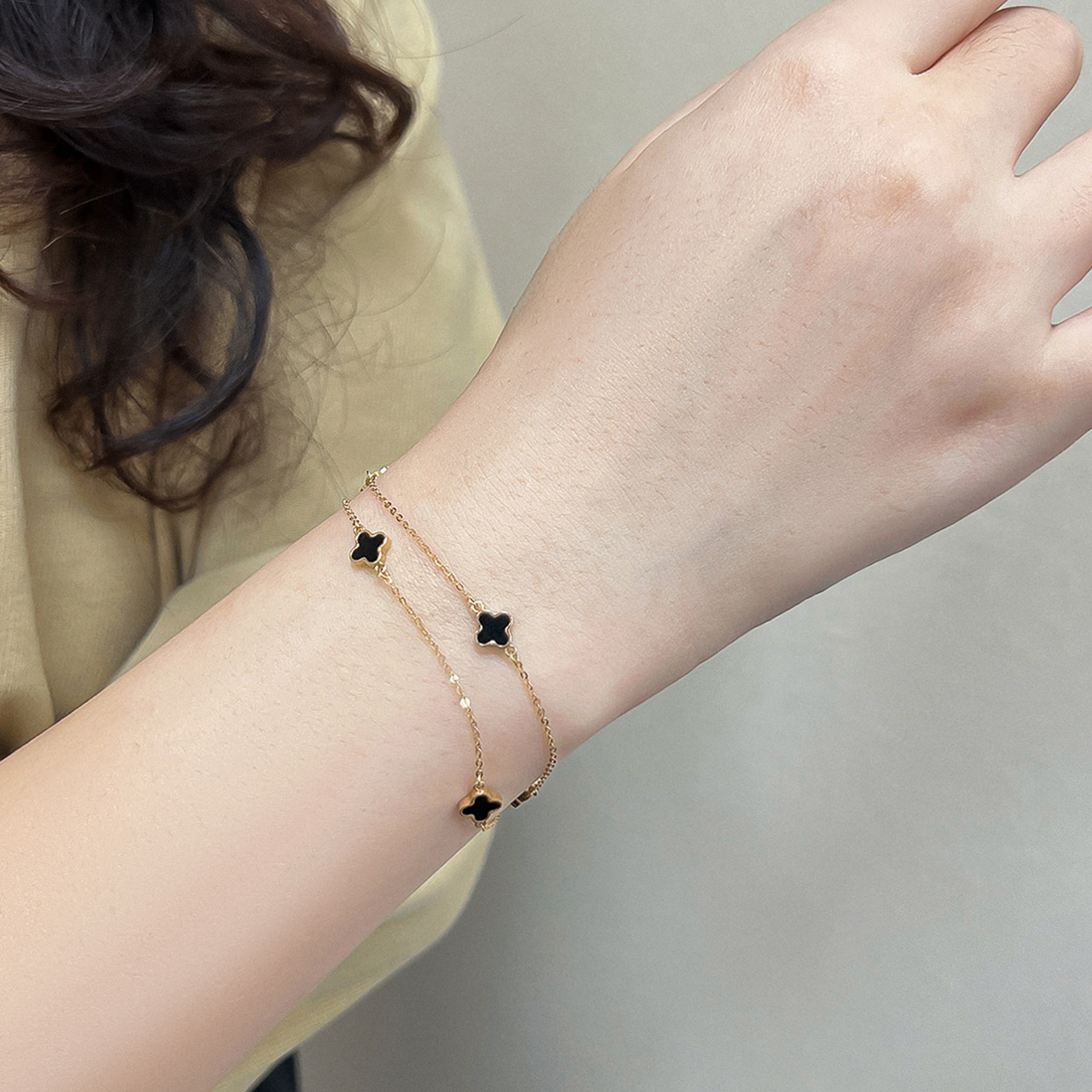 18K clover bracelet delicate gold double chain with black clover charms on wrist