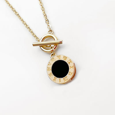 18K Roman clock necklace gold pendant with black enamel center and toggle clasp on delicate chain